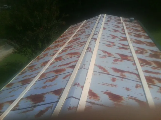 Rusted metal roof panels with new wood purlins before replacement — Storm Damage Roof Repair in Glidden by Roofing Brothers